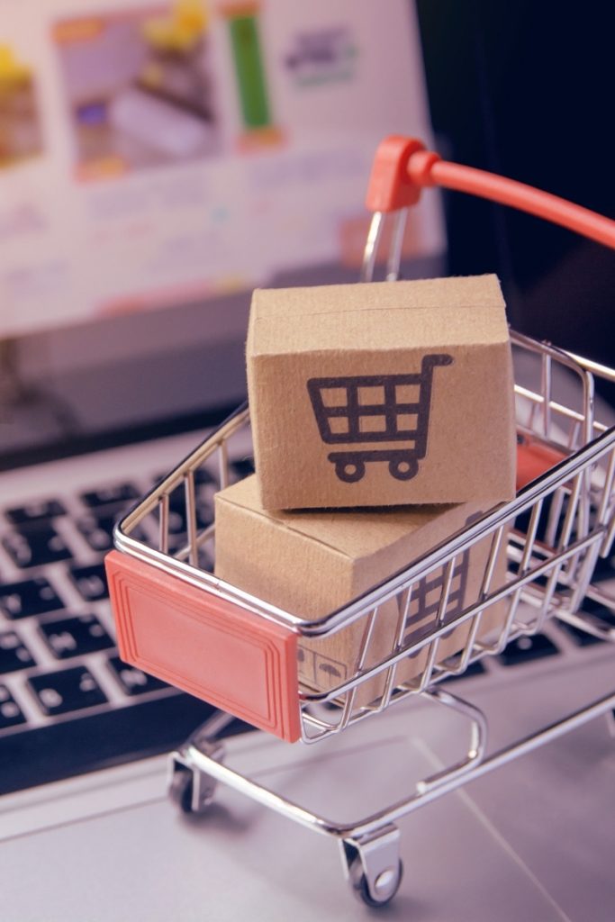 Laptop keyboard holding a little cart and parcels